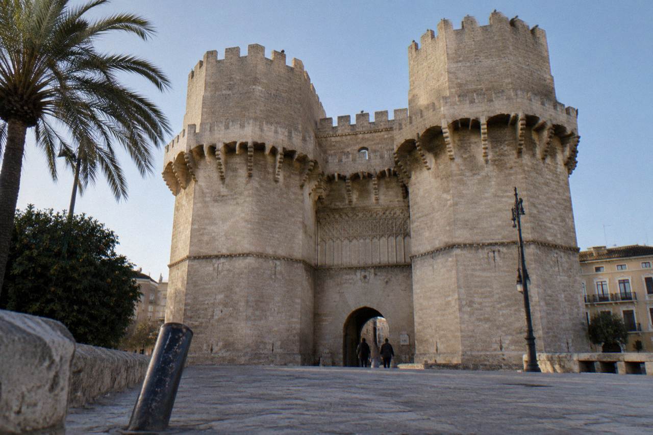 Gothic stone towers and city walls of Valencia old town under a clear morning sky