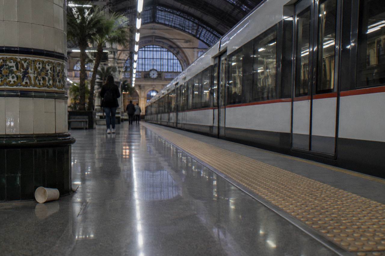 A Valencia metro station platform with a modern train waiting beside the tracks