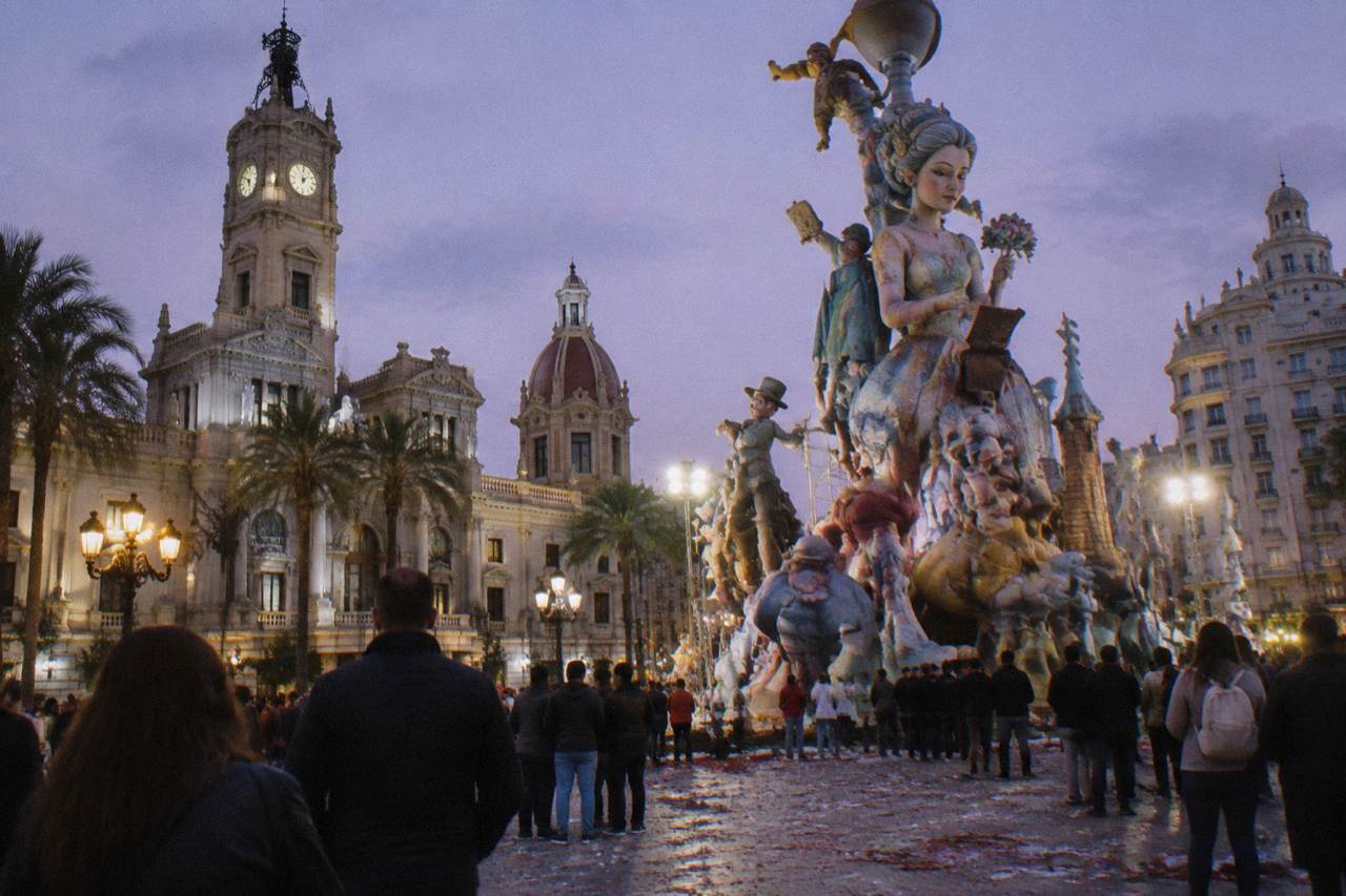 A tall ornate fallas monument standing in a Valencia street with confetti on the pavement
