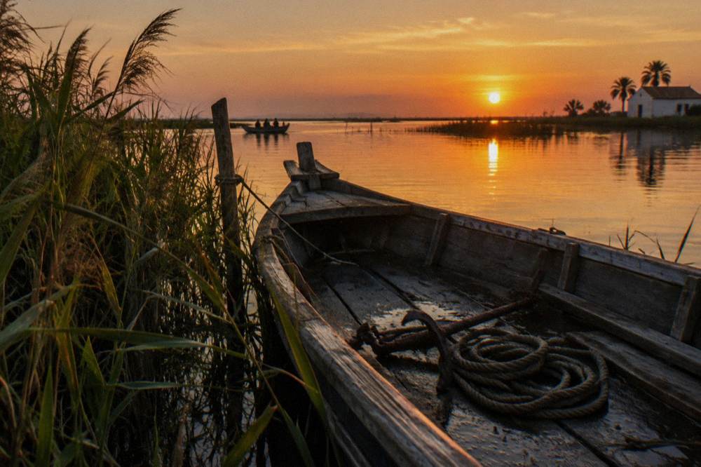 Wooden boat on a calm lagoon surrounded by reeds at sunset