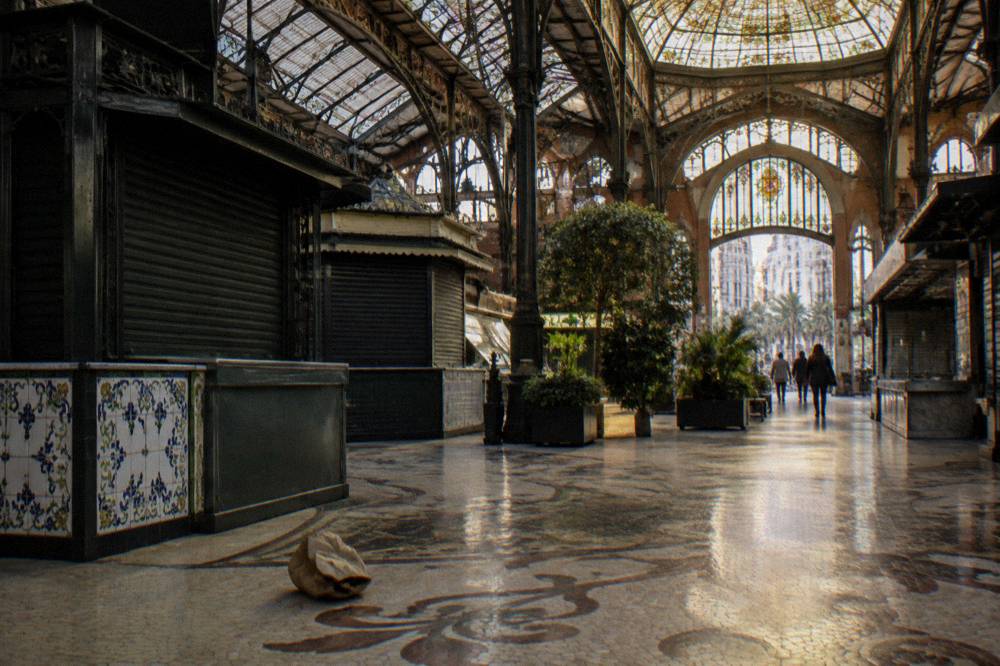 Stained glass ceiling and food stalls inside a large Valencia market hall