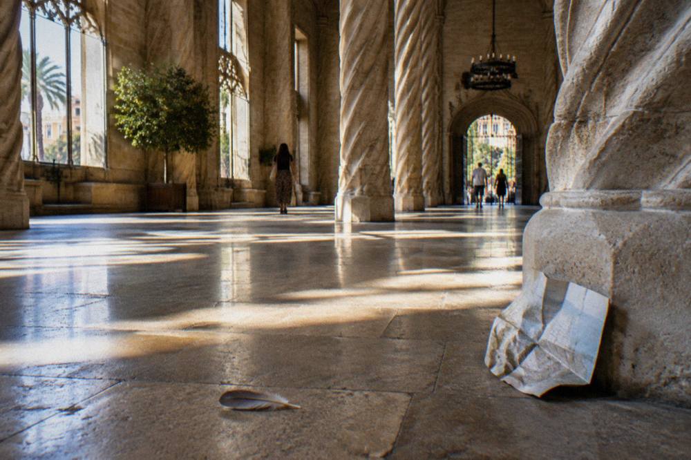Gothic hall with twisted stone columns lit by tall windows