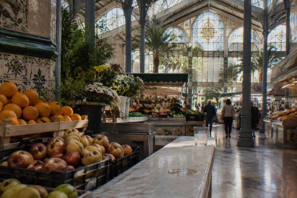 Market hall interior with stalls of fruit under iron and glass architecture