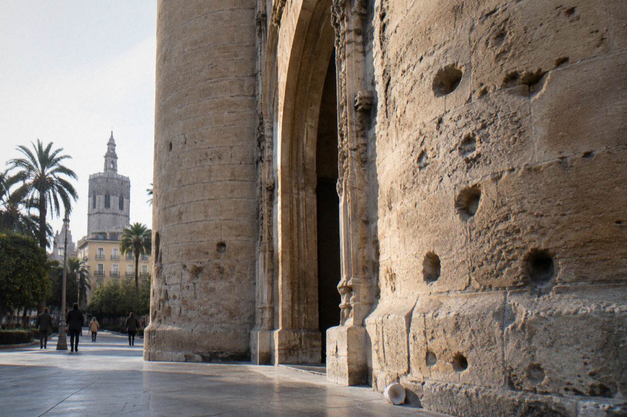 Sunlit stone facade of a Gothic monument in Valencia with ornate carved doorways