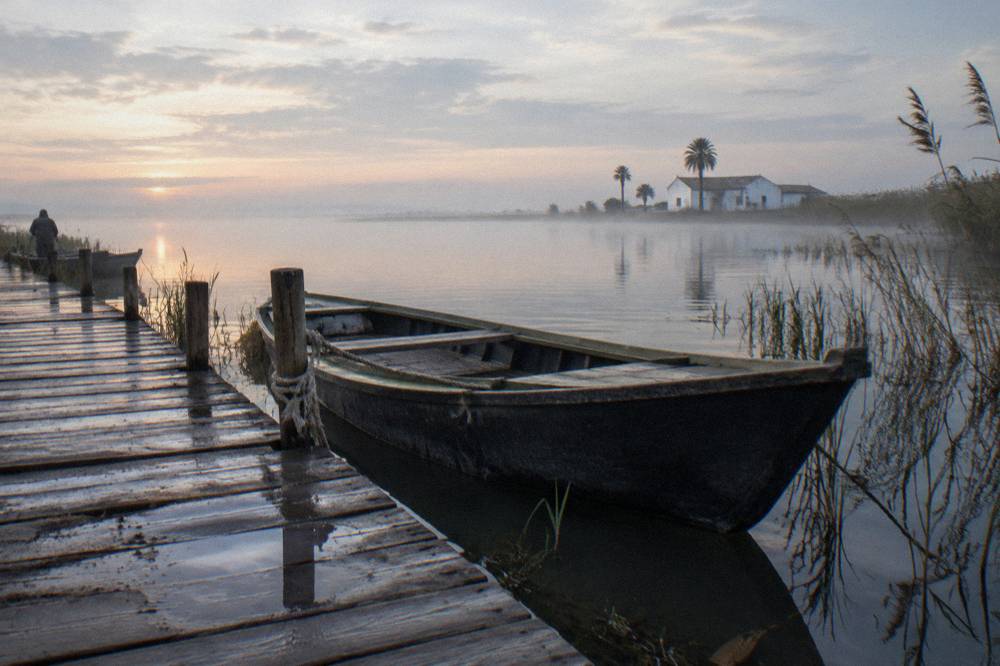 Wooden boat moored at a jetty on the Albufera lagoon