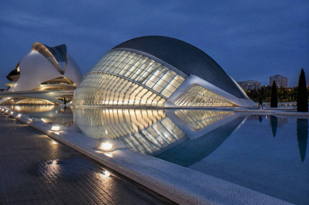 City of Arts and Sciences buildings lit at night with reflections in the pools