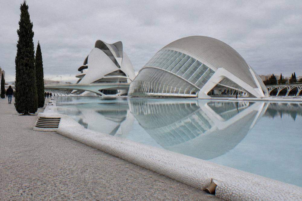 The white curved architecture of the City of Arts and Sciences reflected in still water