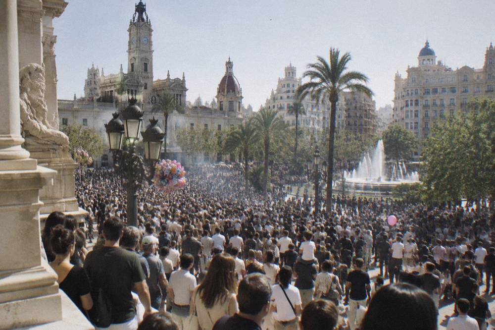Crowds filling a Valencia plaza in daylight waiting for the midday mascleta