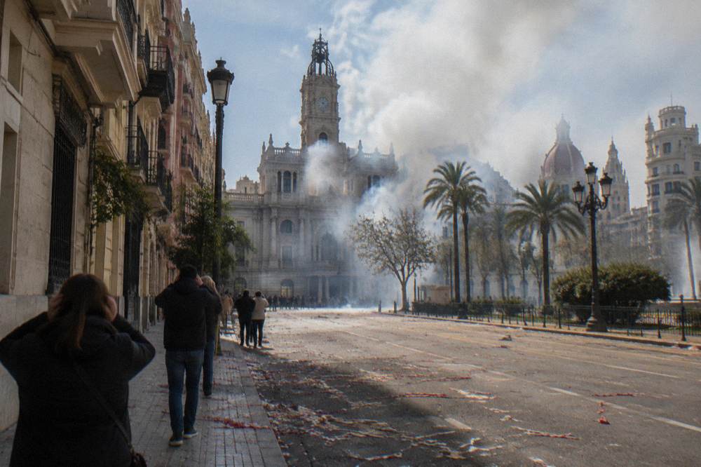 Smoke rising over rooftops in a Valencia square after a midday firecracker barrage