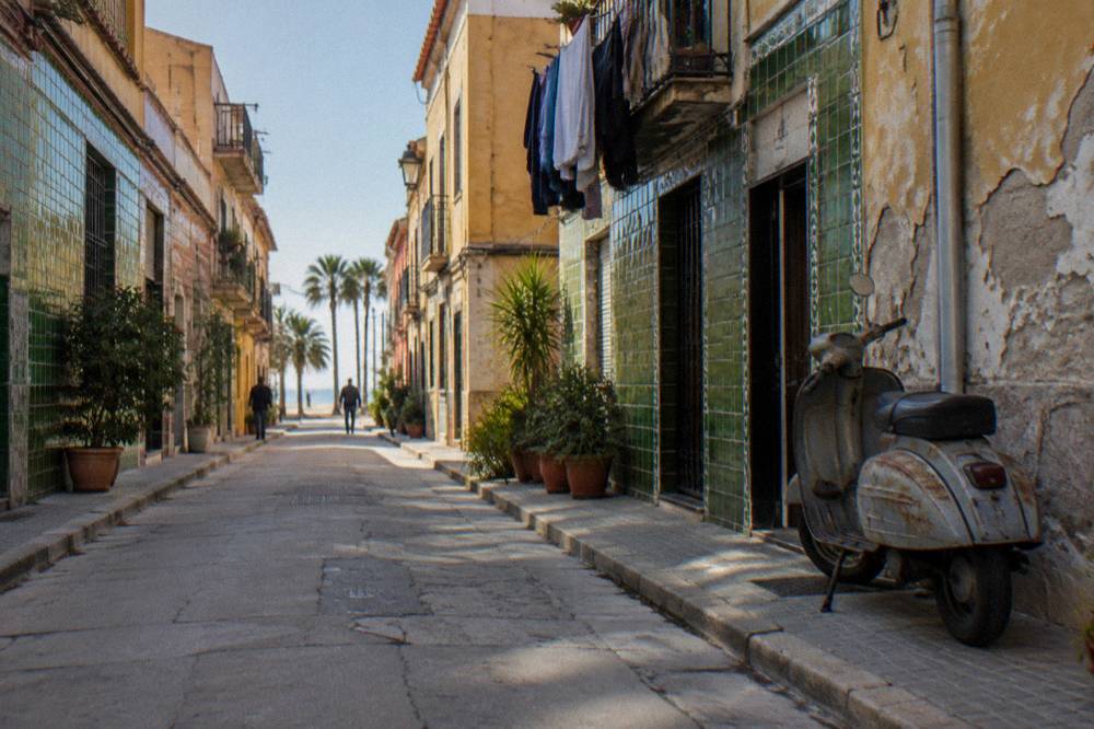 Narrow street lined with colourful tiled building facades in a sunny neighbourhood
