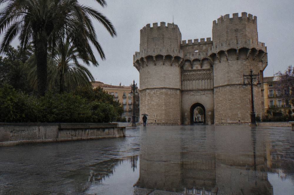 The twin stone towers of Serranos seen from the square below, with the arched gateway between them