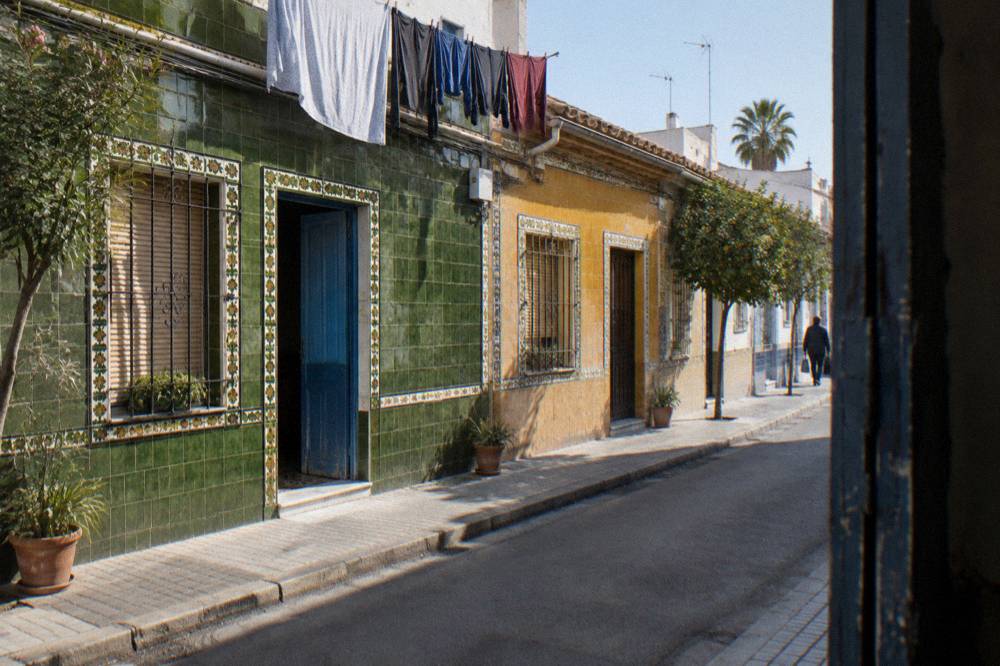 Narrow street of low houses with patterned ceramic facades in a seaside quarter