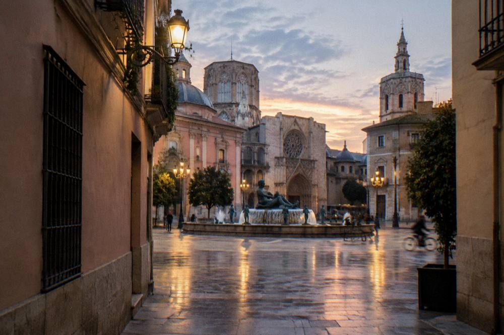 Narrow old town street with pastel facades opening onto a plaza with a fountain