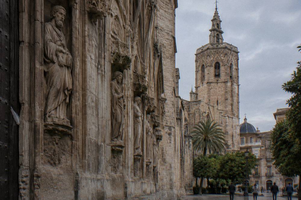 Gothic cathedral doorway with carved stone figures and a bell tower above