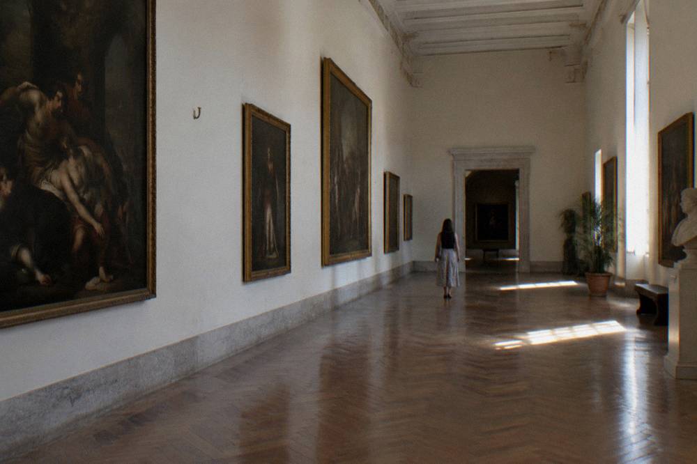 Gallery walls hung with classical paintings inside the fine arts museum of Valencia